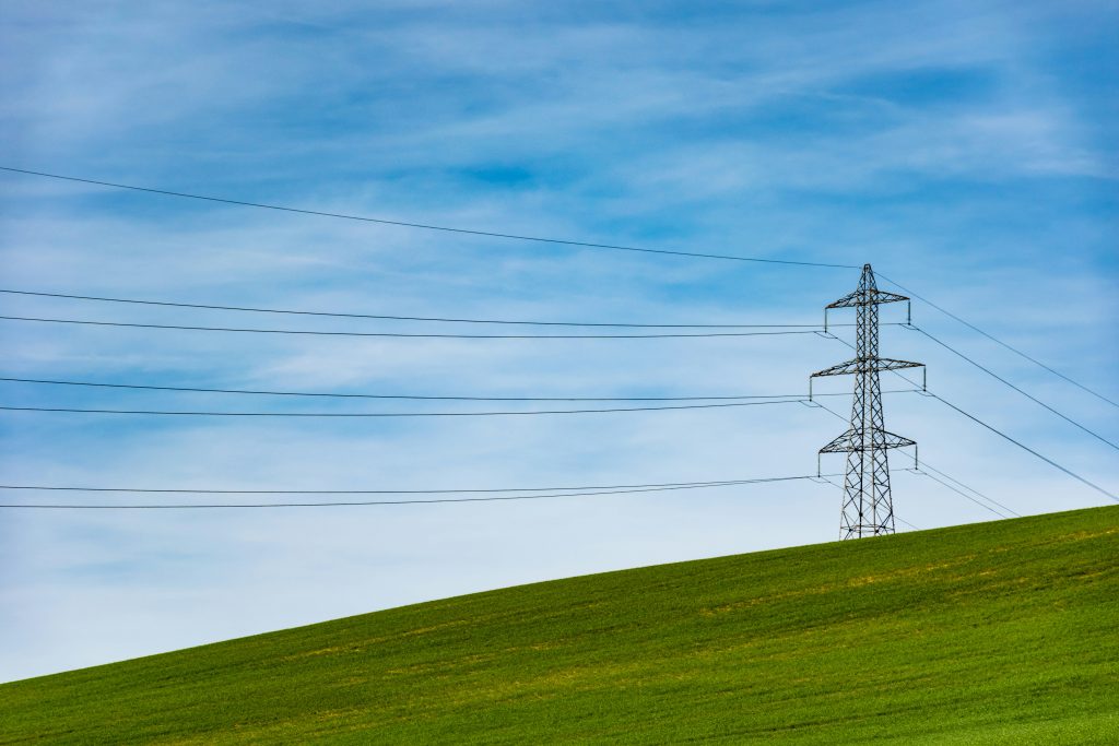 Image of an electrical tower on a grass field